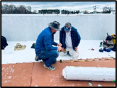 two guys working on TPO flat roofing